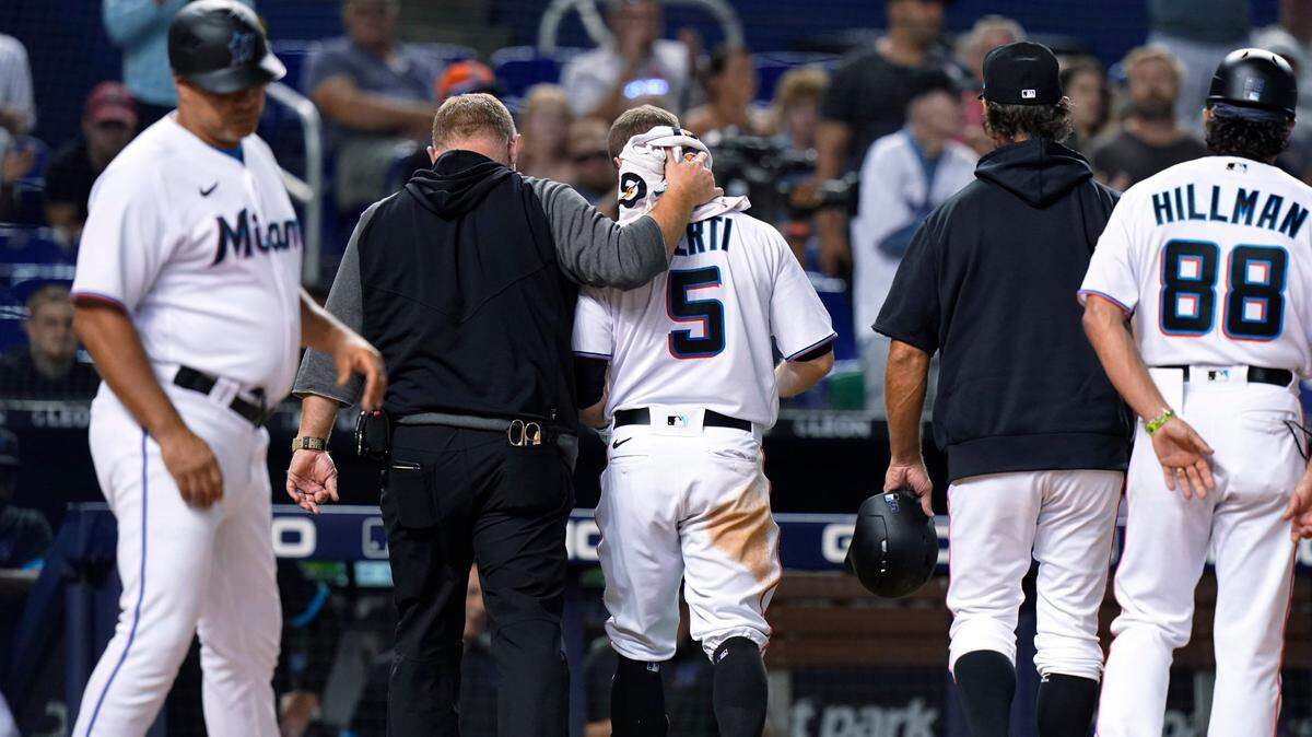 Miami Marlins’ Jon Berti (5) is led off the field after being hit by a pitch by San Diego Padres reliever Austin Adams during the seventh inning of a baseball game Thursday, July 22, 2021, in Miami. The Padres won 3-2. (AP Photo/Lynne Sladky)