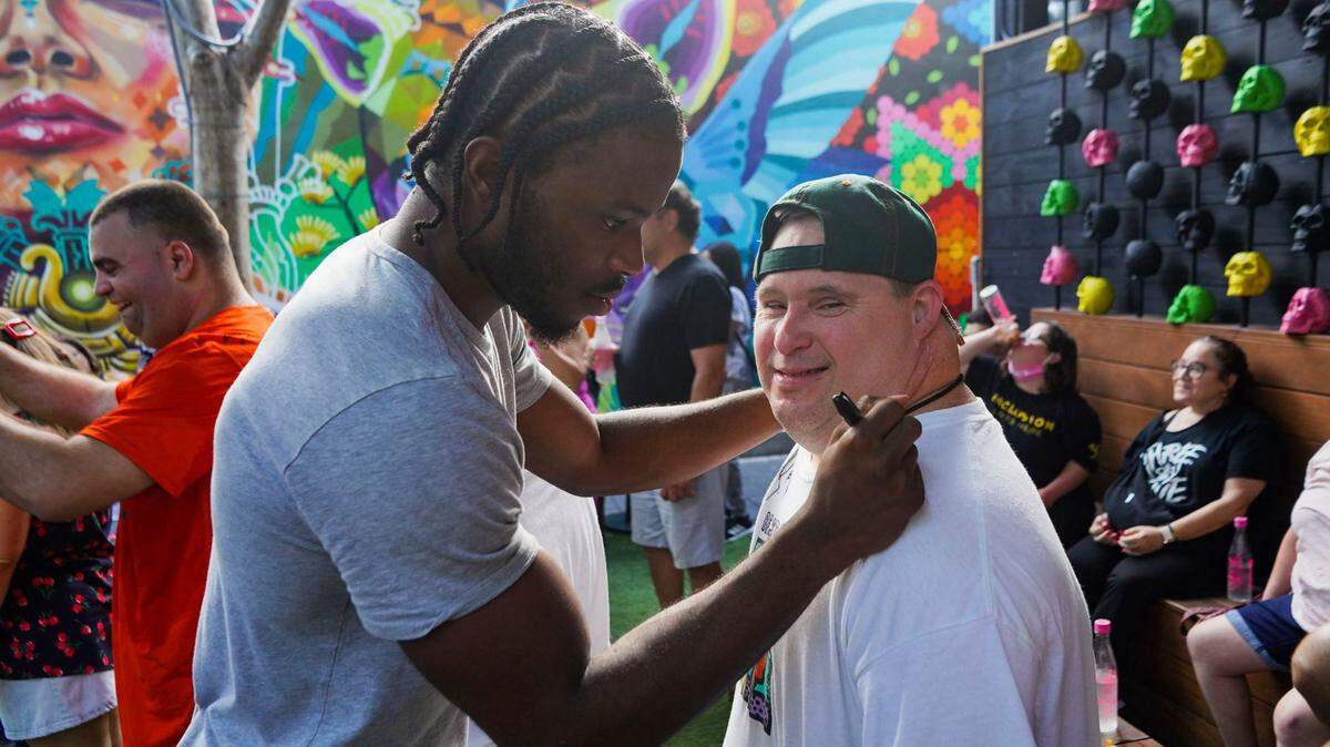 Miami Hurricanes cornerback Al Blades signs the t-shirt of a patron at Pilo’s Tequila Garden in Wynwood during a July 26, 2021 NIL appearance by him and teammates D’Eriq King and Ryan Ragone. Under the guidance of attorney Adam Arnaout, they met and mingled with people with special needs who are supported in their efforts by the restaurant.