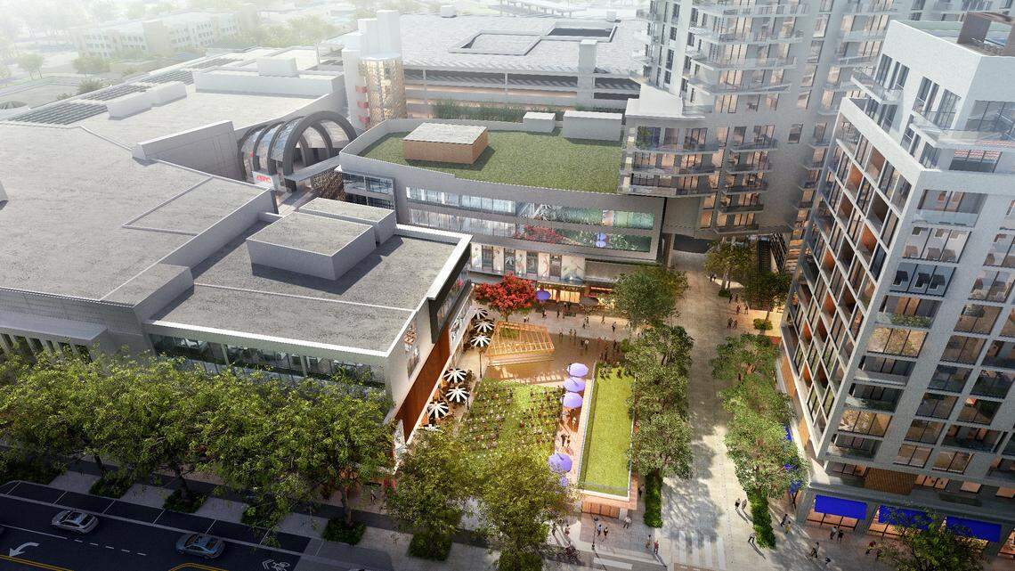 An architectural overhead rendering of the redeveloped Shops at Sunset Place shows: solar panel arrays atop the roof at left; a new public plaza opening to Red Road at center; and, at right, residential and hotel towers that will replace the north end of the mall, which will be demolished.