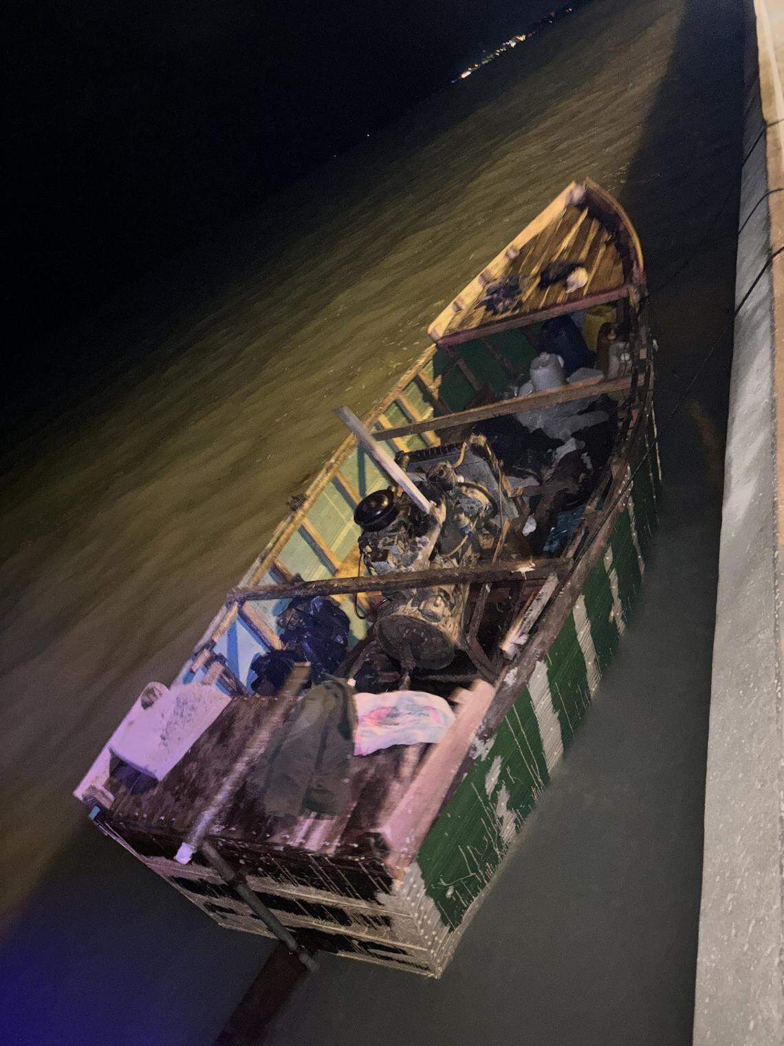 A migrant boat is moored to a seawall in Key West. The Border Patrol said a group of 18 people from Cuba arrived on the homemade vessel Sunday night, Dec. 29, 2024.