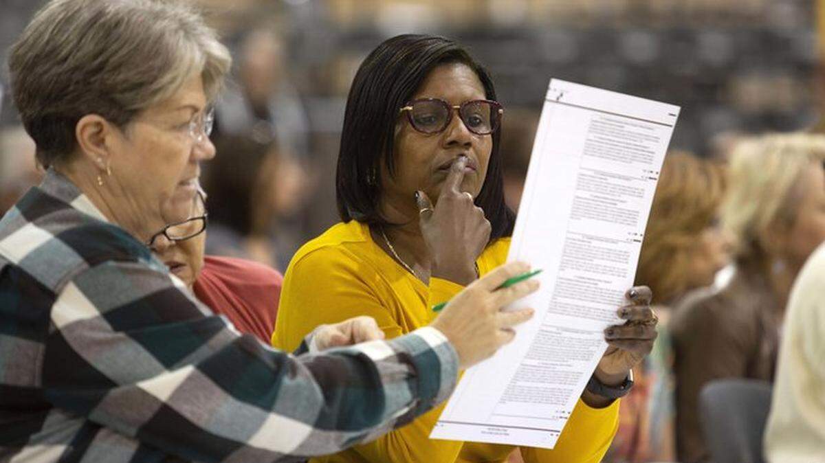 Volunteers examine a ballot during a hand recount in Palm Beach County in 2018.