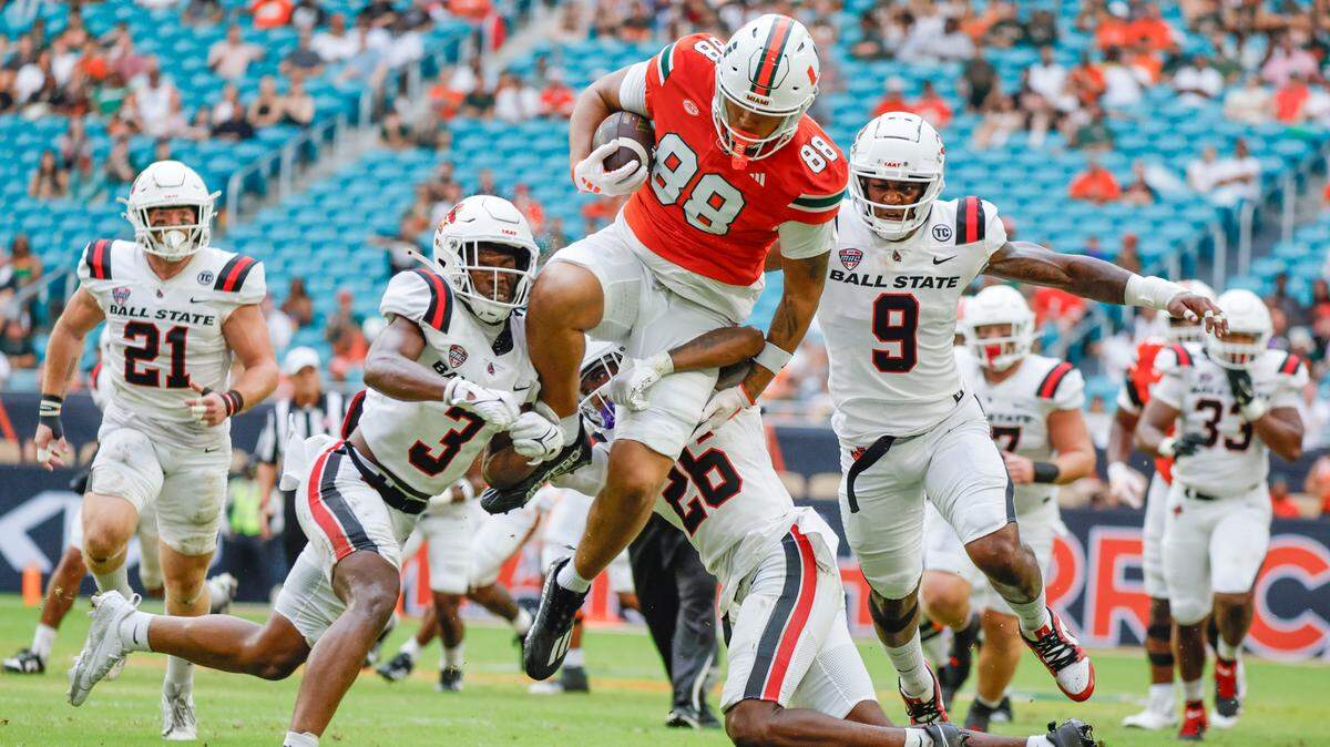Miami Hurricanes tight end Riley Williams (88) Ball State Cardinals defensive back Dd Snyder (3) and cornerback Myles Norwood (26) defend in the first half of an NCAA football game at Hard Rock Stadium in Miami Gardens, Florida on Saturday, September 14, 2024.