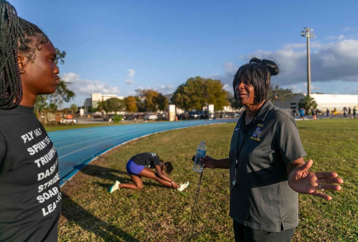 Miami Northwestern Senior High track and field coach Carmen Jackson talks to Kimora Kinsey, 16, during a team practice at their school on Wednesday, Feb. 8, 2023, in Miami, Fla.