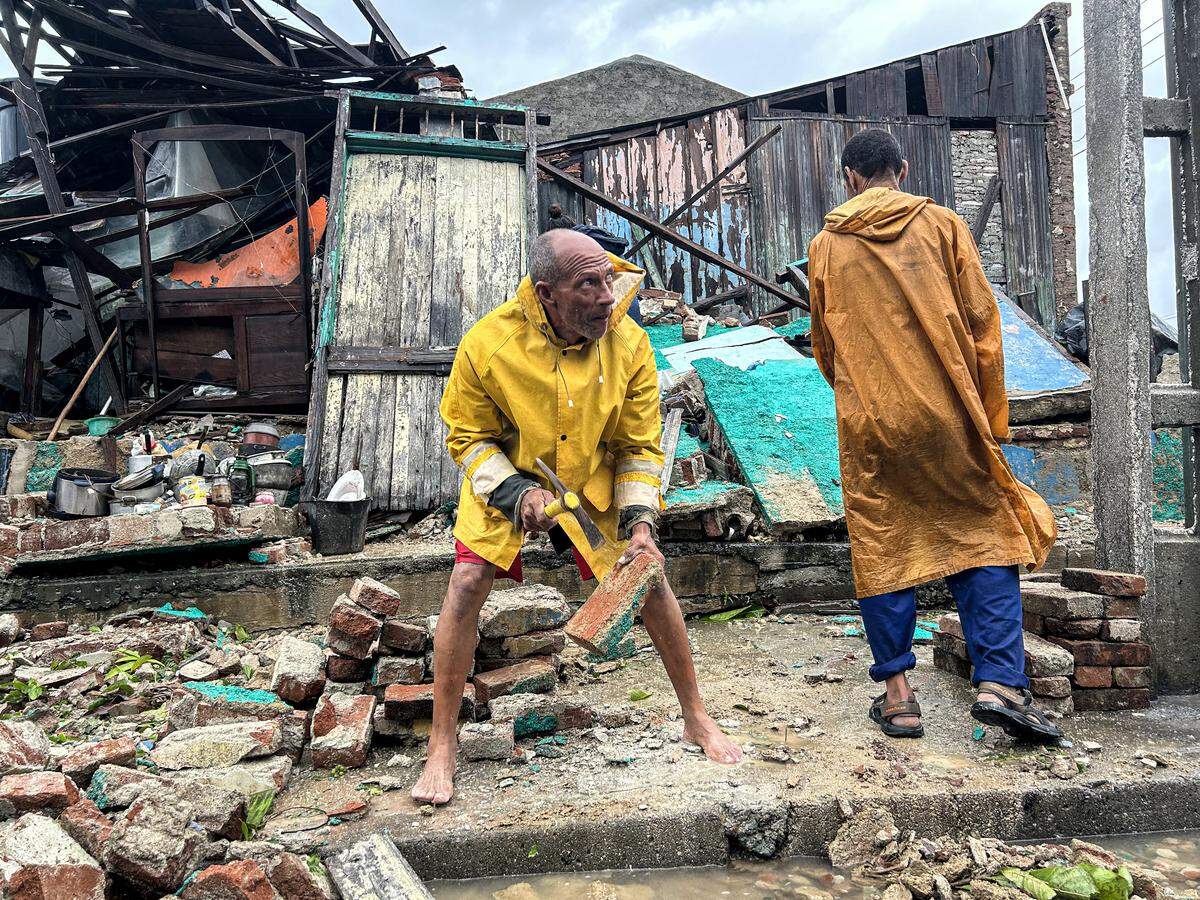 A family salvages belongings from the rubble of their home after it collapsed during Hurricane Melissa's passage through Santiago de Cuba, Cuba, on October 29, 2025. A powerful Hurricane Melissa made landfall in eastern Cuba on Wednesday, causing damage and flooding to homes and streets in Santiago de Cuba province, an AFP team on the ground reported. 