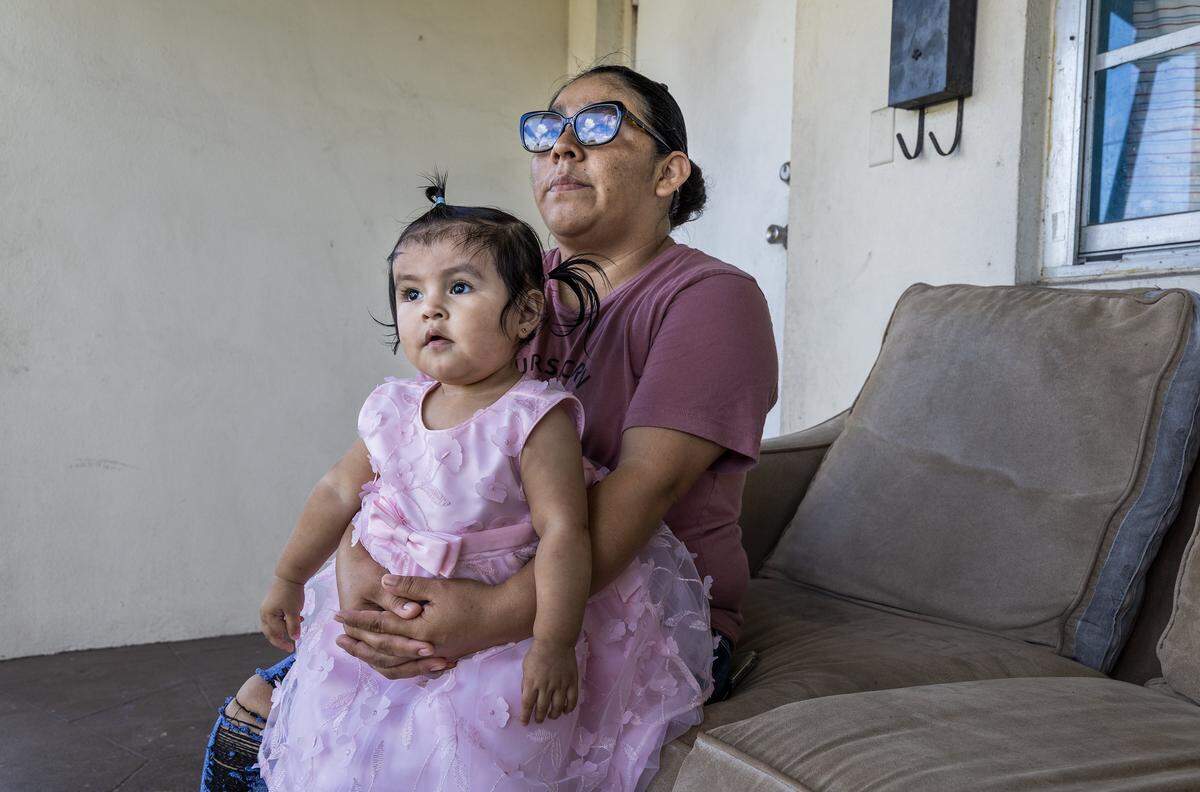 Farmer worker Leyla Ac Choc of Guatemala holds her daughter Melany Reynoso, 14.m.o, as she talks about her financial hardship and change in living situation after her husband was deported, leaving her as the sole family provider. In Homestead on Saturday, November 15, 2025.