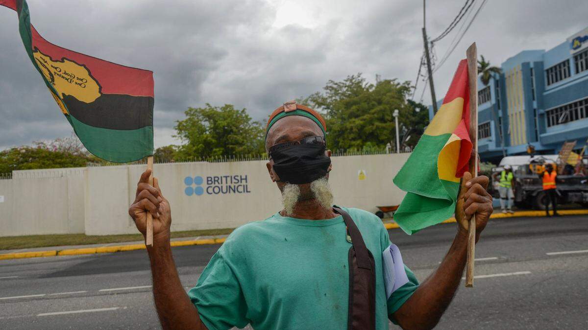 A man protests outside the British High Commission in Kingston to demand an apology and slavery reparations during a visit to the former British colony by the Duke and Duchess of Cambridge, Prince William and Kate, in Kingston, Jamaica, Tuesday, March 22, 2022. The two-day visit to Jamaica is part of a larger trip to the Caribbean region encouraged by Queen Elizabeth II as some countries debate cutting ties with the monarchy like Barbados did late last year.