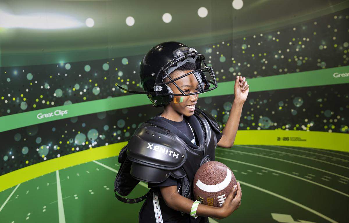 Raymond Manaigo Jr., 10, strikes a pose as he visits the Playoff Fan Central at the Miami Beach Convention Center on Friday, Jan. 16, 2025, in Miami Beach, Fla. Fans can visit the event ahead of the College Football Playoff National Championship Game between the Miami Hurricanes and the Indiana Hoosiers and enjoy a variety of family-friendly interactive experiences.