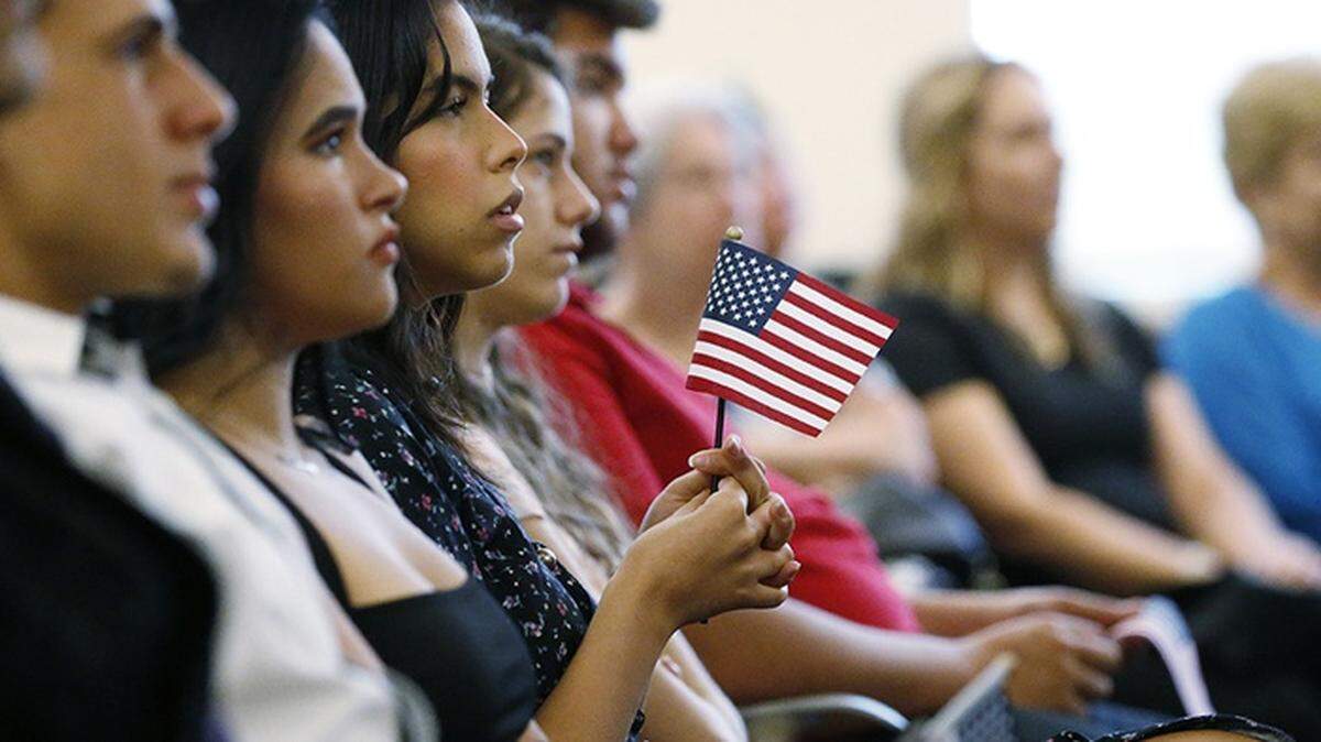 A new citizen holds an American flag during a naturalization ceremony in Miami in 2018.