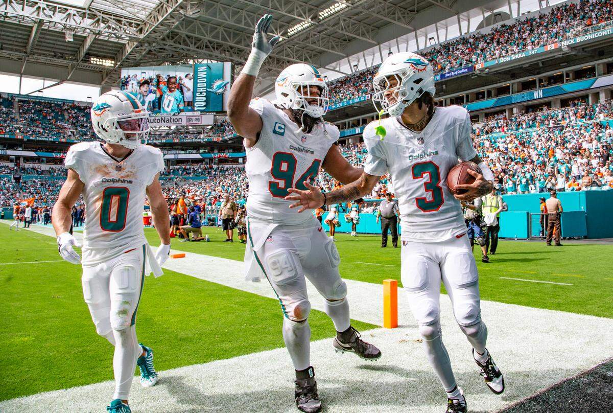 Miami Dolphins wide receiver Robbie Chosen (3) celebrates with teammates Miami Dolphins wide receiver Braxton Berrios (0) and Miami Dolphins defensive tackle Christian Wilkins (94) after Chosen scores in the fourth quarter against the Denver Broncos at Hard Rock Stadium in Miami Gardens on Sunday, September 24, 2023.