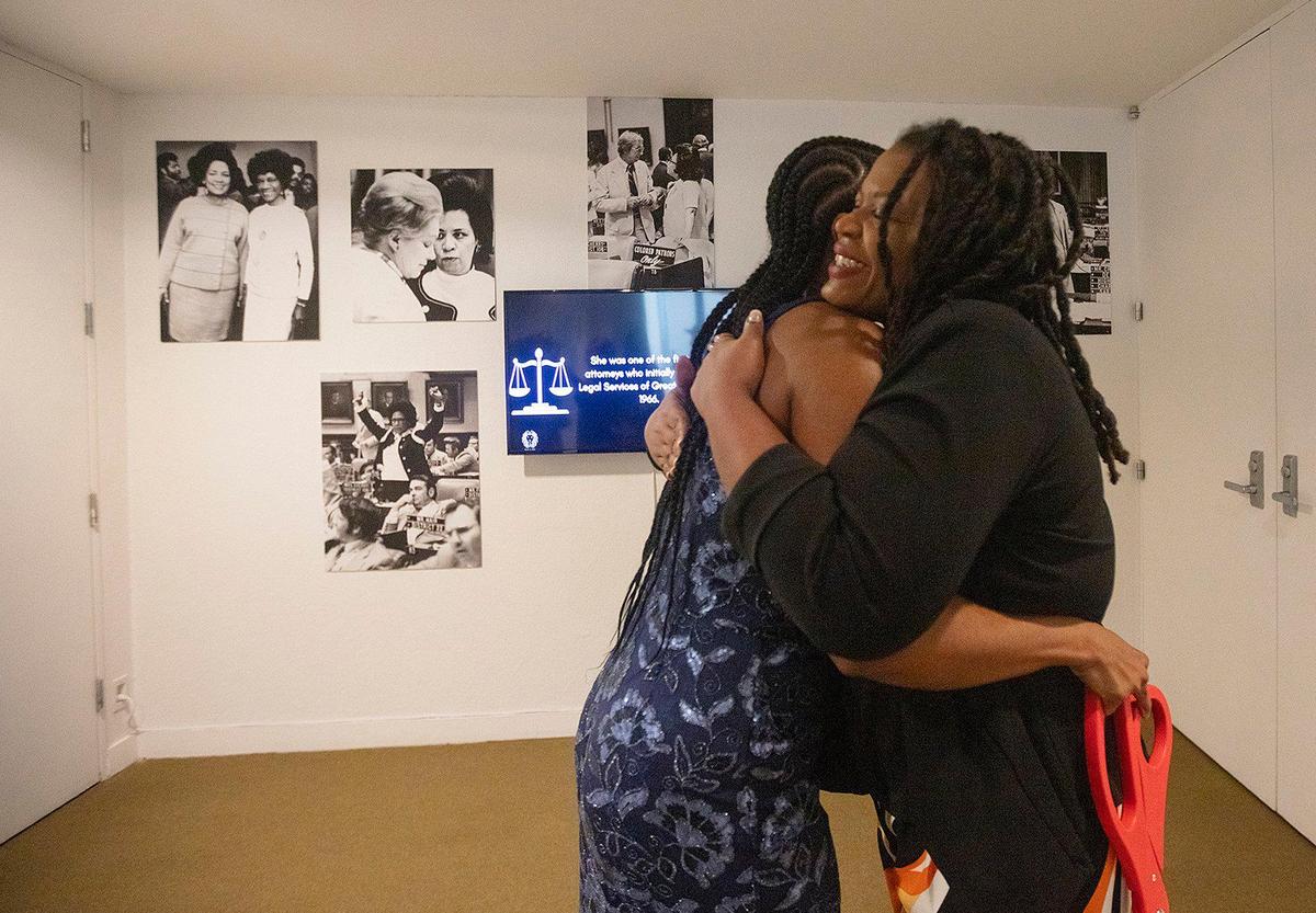 Florida State Representative Ashley V. Gantt (l) hugs Kamila Pritchett, Executive Director of the Black Archives at the opening of Gwen Cherry exhibit at the HistoryMiami.