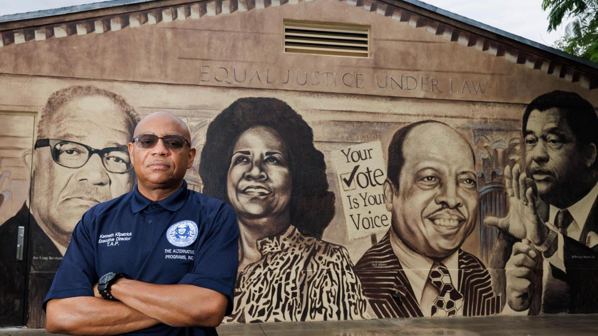 Kenneth Kilpatrick, president of the Brownsville Civic Neighborhood Association, poses with a mural of neighborhood historical figures on Wednesday, July 23, 2025 in the Brownsville neighborhood of Miami, Fla. Kilpatrick thinks there more pros than cons to becoming a city. “There’s enough dormant space to bring in [needed resources]…and make sure our money doesn’t leave the city,” said Kilpatrick.