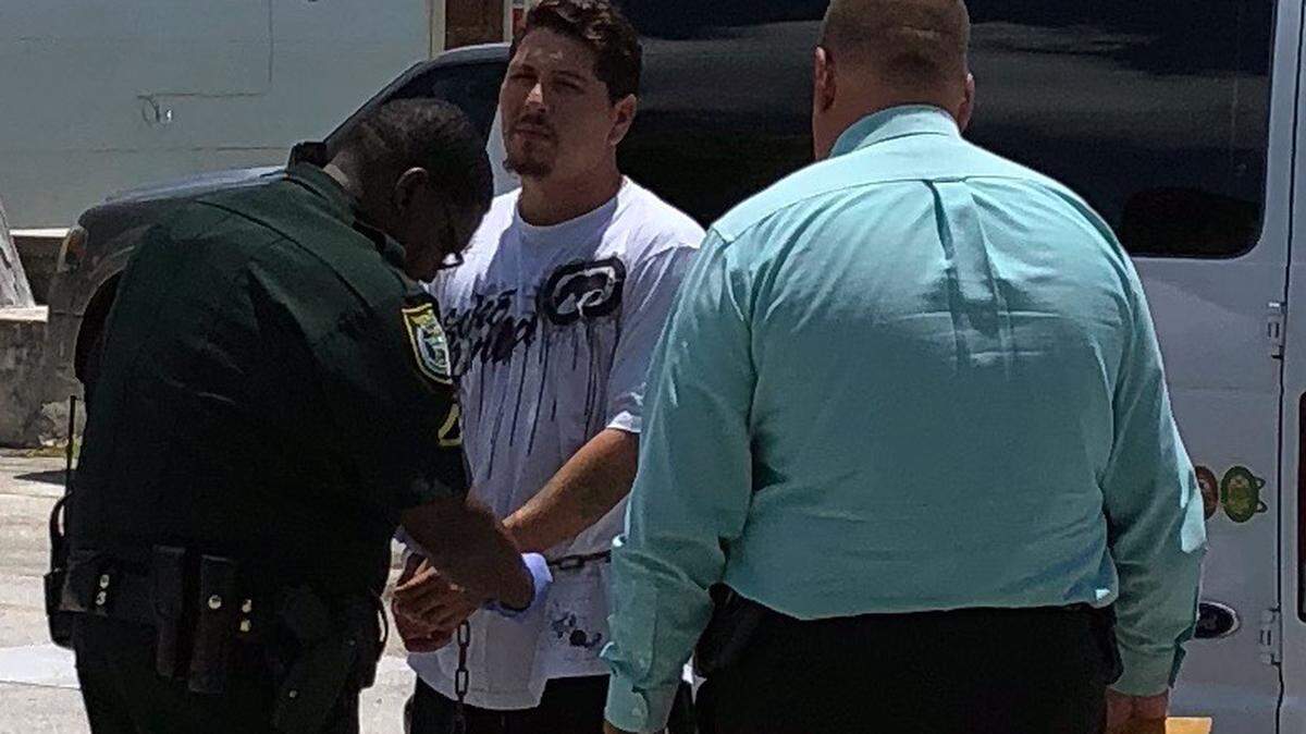 A Monroe County Sheriff’s Office deputy cuffs Giovanni Alberto Fernandez after his arrest on battery, kidnapping and armed burglary charges Thursday, Aug. 23, 2018.