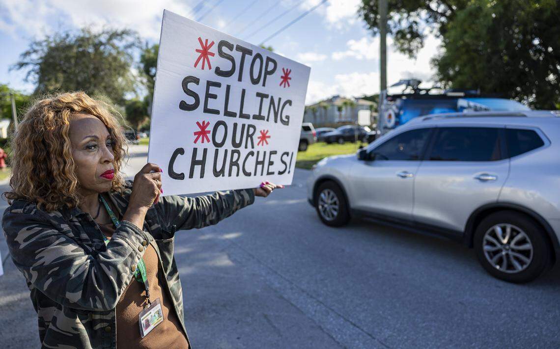 Faye Brown holds a sign as she gathers with fellow activists to protest outside the House of God Church, Keith Dominion, on Friday, Sept. 19, 2025, in Pompano Beach, Fla. Members of South Florida congregations organized the protest after learning that longtime churches were being sold for what they say is below market value.