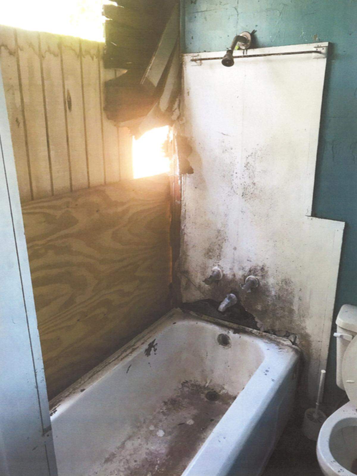 A photograph shows a dilapidated bathroom in one of Rasken’s houses on Charles Avenue. Rasken says the previous owner left the property in dire condition.