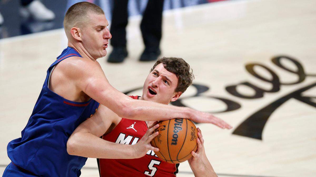 Denver Nuggets center Nikola Jokic (15) knocks the ball away from Miami Heat forward Nikola Jovic (5) during the fourth quarter in game one of the 2023 NBA Finals at Ball Arena.
