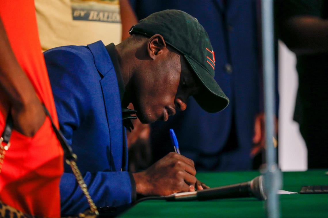 Miami Central High School linebacker Wesley Bissainthe signs his letter of intent to play college football for the Canes at the University of Miami during a ceremony at the Miami Central High School auditorium on Wednesday, December 15, 2021
