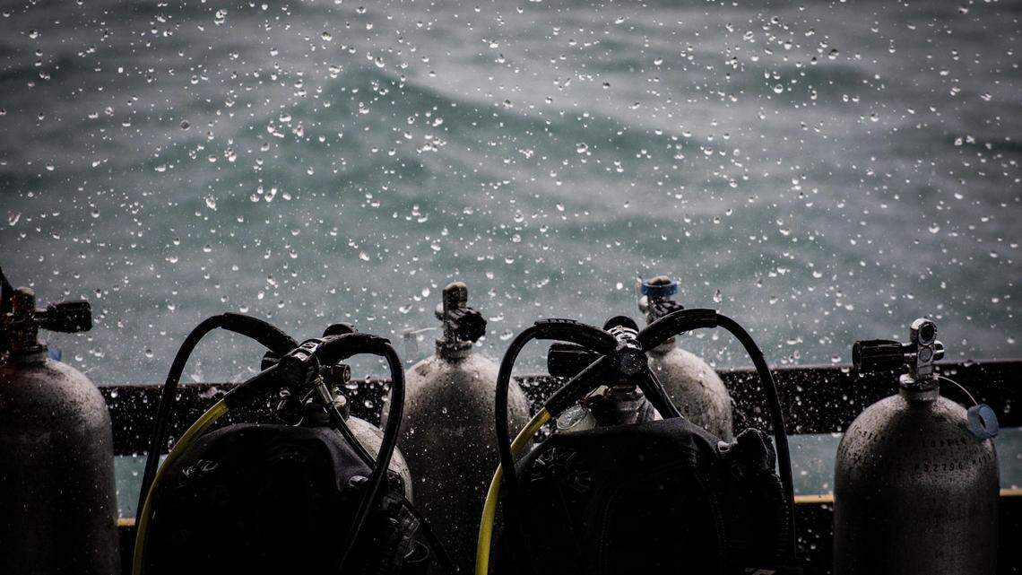 Scuba divers entered the HMS Scylla shipwreck near Plymouth, becoming disoriented, officials said. One escaped; two ran out of air and died.