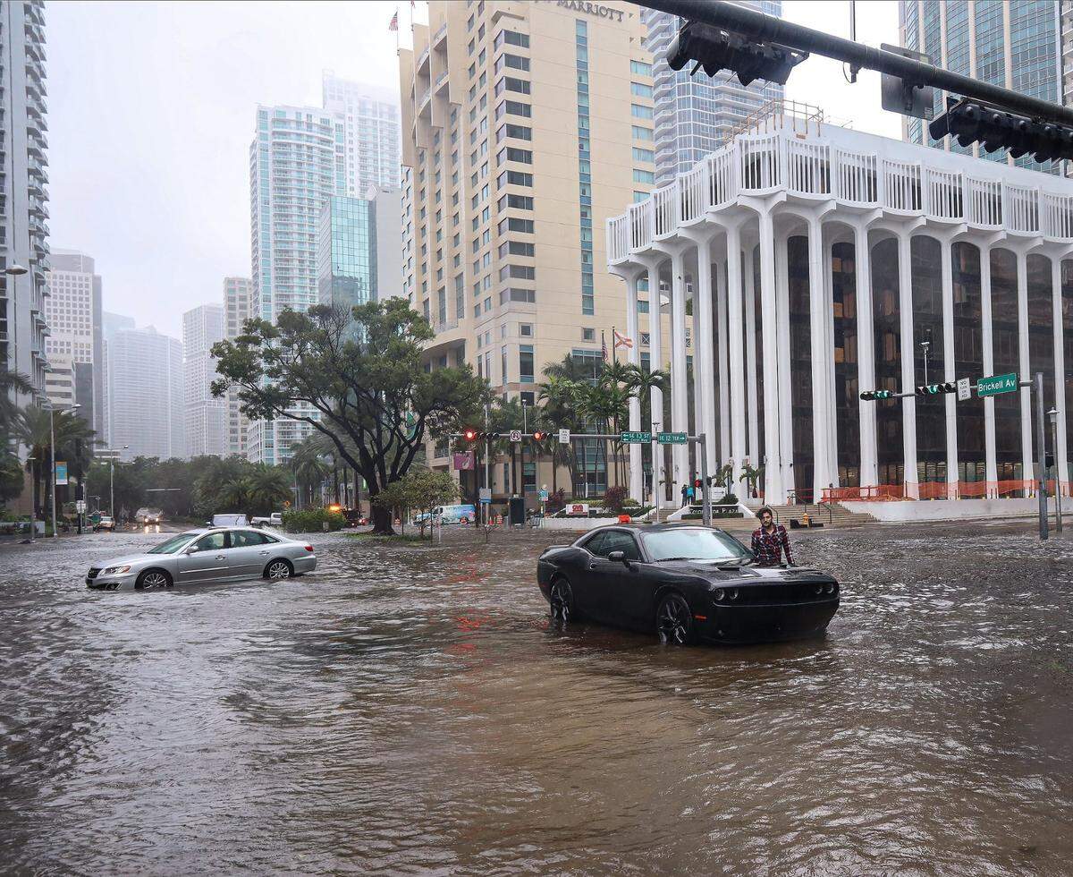 Un conductor de pie junto a su Dodge último modelo después de que el auto quedara inmovilizado cuando la tormenta tropical Eta azotó Miami, dejando a los automovilistas que cruzaban la intersección de SW 13 Street y Brickell Avenue atascados en el agua de las inundaciones debido a las fuertes lluvias del 9 de noviembre de 2020.