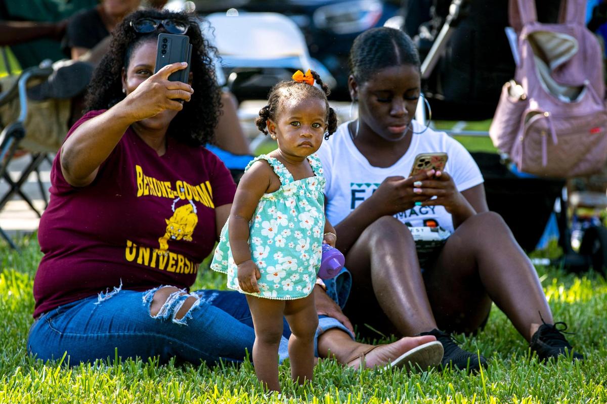 Bethune-Cookman University alumnus Michelle Davis, 50, left, and Dr. Imani Spivey, 25, right, sit with Serae Johnson Lipkins, 1, center, during the 6th Annual South Florida HBCU Picnic at Florida Memorial University in Miami Gardens, Florida, on Saturday, July 9, 2022. The trio are grandmother, daughter, and granddaughter.