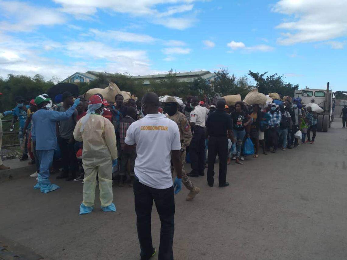 Workers from Haiti’s health ministry take the temperatures of returning migrants on the Ouanaminthe-Dajabón border in northeast Haiti. Thousands of Haitians have fled the Dominican Republic in the last several weeks due to the coronavirus and, despite the border being closed, some are going undetected as they cross unofficial crossings.