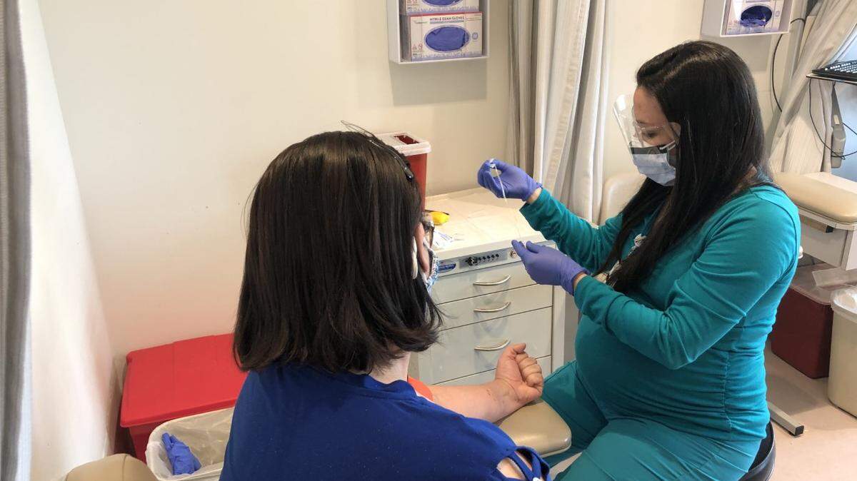 Marialuisa Fuentes, asistente médica del Maroone Cancer Center de Cleveland Clinic en Weston, se prepara para tomar una muestra de sangre a un paciente que se somete a una prueba genética.