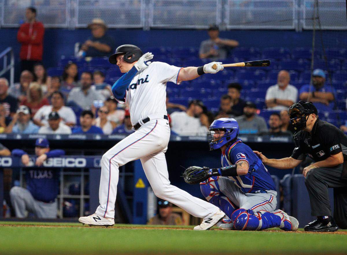 Miami Marlins designated hitter Garrett Cooper (26) hits a single during the third inning of a baseball game against the Texas Rangers at LoanDepot Park on Thursday, July 21, 2022 in Miami, Florida.