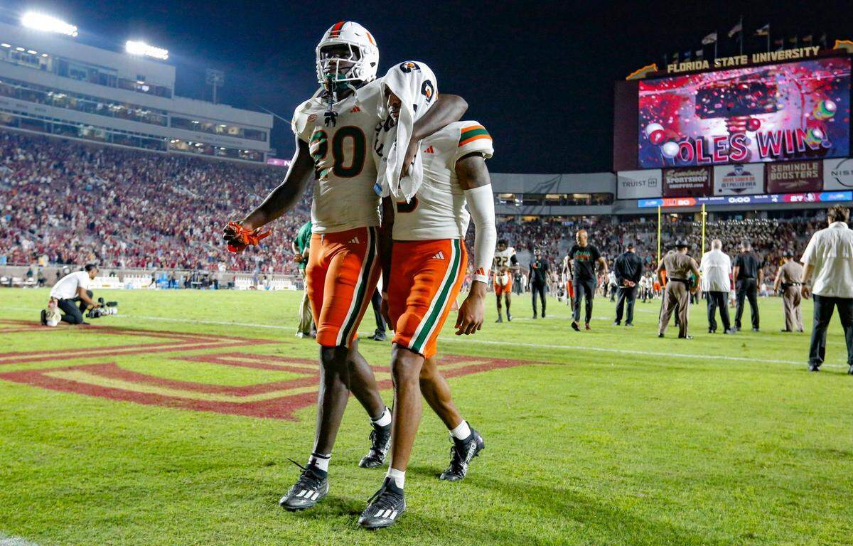 `Miami Hurricanes safety James Williams (20) and wide receiver Jacolby George (3) walk off the field together after the loss to Florida State Seminoles at Doak Campbell Stadium in Tallahassee on Saturday, November 11, 2023.