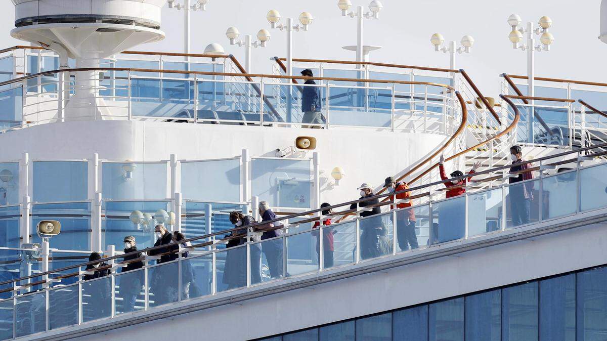 Passengers stand on the deck of the Diamond Princess cruise ship anchored at Yokohama Port in Yokohama, near Tokyo, Wednesday, Feb. 12, 2020. Japan’s health ministry said Wednesday that 39 new cases of a virus have been confirmed on the cruise ship quarantined at the Japanese port. (Yuta Omori/Kyodo News via AP)