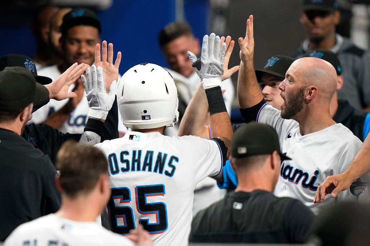Miami Marlins’ Jordan Groshans (65) is congratulated in the dugout after hitting a solo home run during the third inning of the team’s baseball game against the Philadelphia Phillies, Thursday, Sept. 15, 2022, in Miami. (AP Photo/Lynne Sladky)