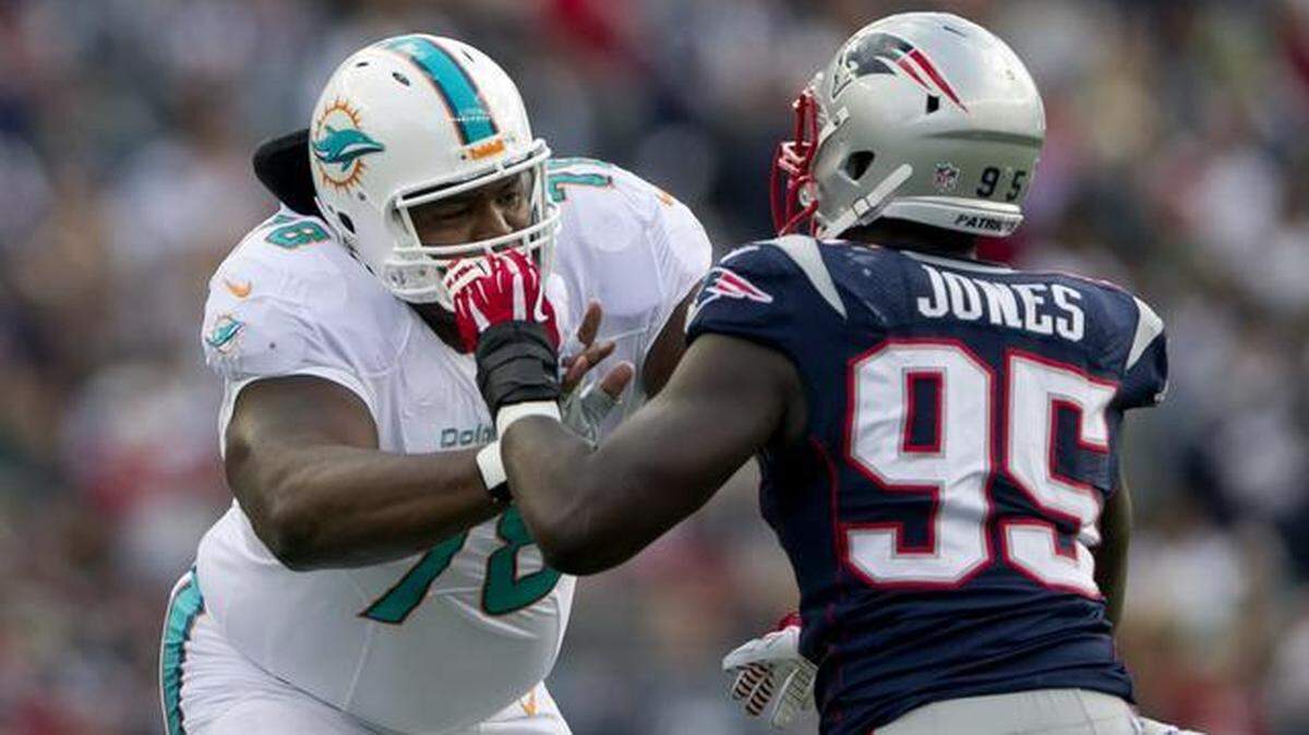 New tackle Bryant McKinnie blocks defensive end Chandler Jones (95) in the first quarter in the game with the Miami Dolphins and New England Patriots at Gillette Stadium in Foxboro on October 27,2013.