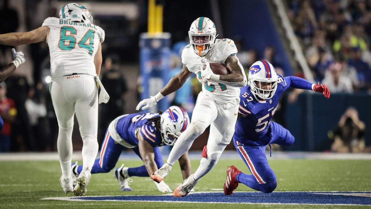 Miami Dolphins running back Ollie Gordon II (31) on a carry as Buffalo Bills defensive end AJ. Epenesa (57) and outside linebacker Shaq Thompson (45) fail to make the tackle in the second half of their NFL football game at Highmark Stadium in Orchard Park, NY, on Thursday, September 18, 2025.