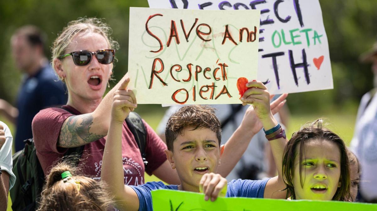 John Lourenco, 10, at center, joins protesters with Keep Florida State Parks Wild-Defend Oleta State Park against the Florida Department of Environmental Protection’s plan to add pickleball courts, cabins, and a disc golf course to Oleta River State Park in North Miami Beach, Florida on Tuesday, August 27, 2024.