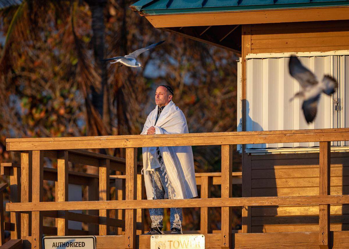South Florida resident Timor Klinghofer taking in the sunrise under the cold weather at the Newport Fishing Pier on Tuesday, Jan. 30, 2024 in Sunny Isles Beach, Florida.