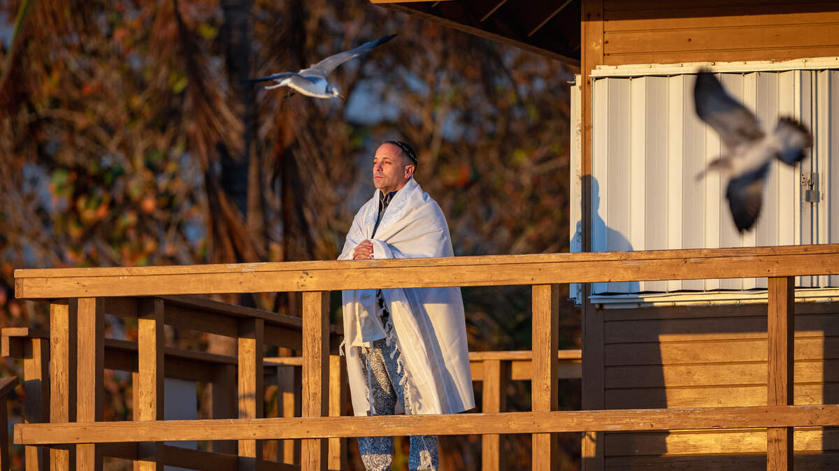 South Florida resident Timor Klinghofer taking in the sunrise under the cold weather at the Newport Fishing Pier on Tuesday, Jan. 30, 2024 in Sunny Isles Beach, Florida.