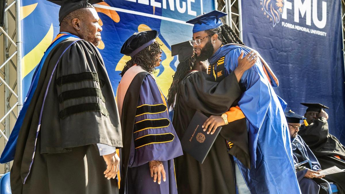 FMU faculty members greet student Perontay Cecil Antonio Fawkes, business graduate, during the spring 2023 commencement ceremony at Florida Memorial University in Miami Gardens, on Saturday May 14, 2022.