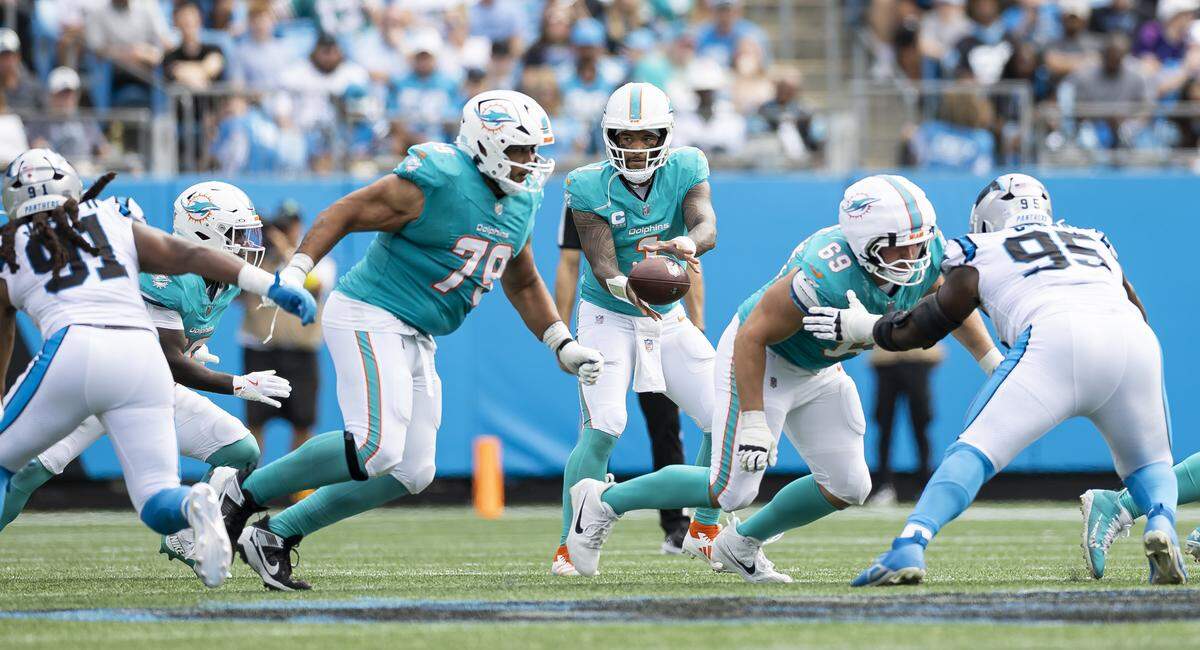 Miami Dolphins quarterback Tua Tagovailoa (1) receives the ball in the second half of his NFL game against the Carolina Panthers at the Bank of America Stadium on Sunday, Oct. 5, 2025, in Charlotte, N.C.