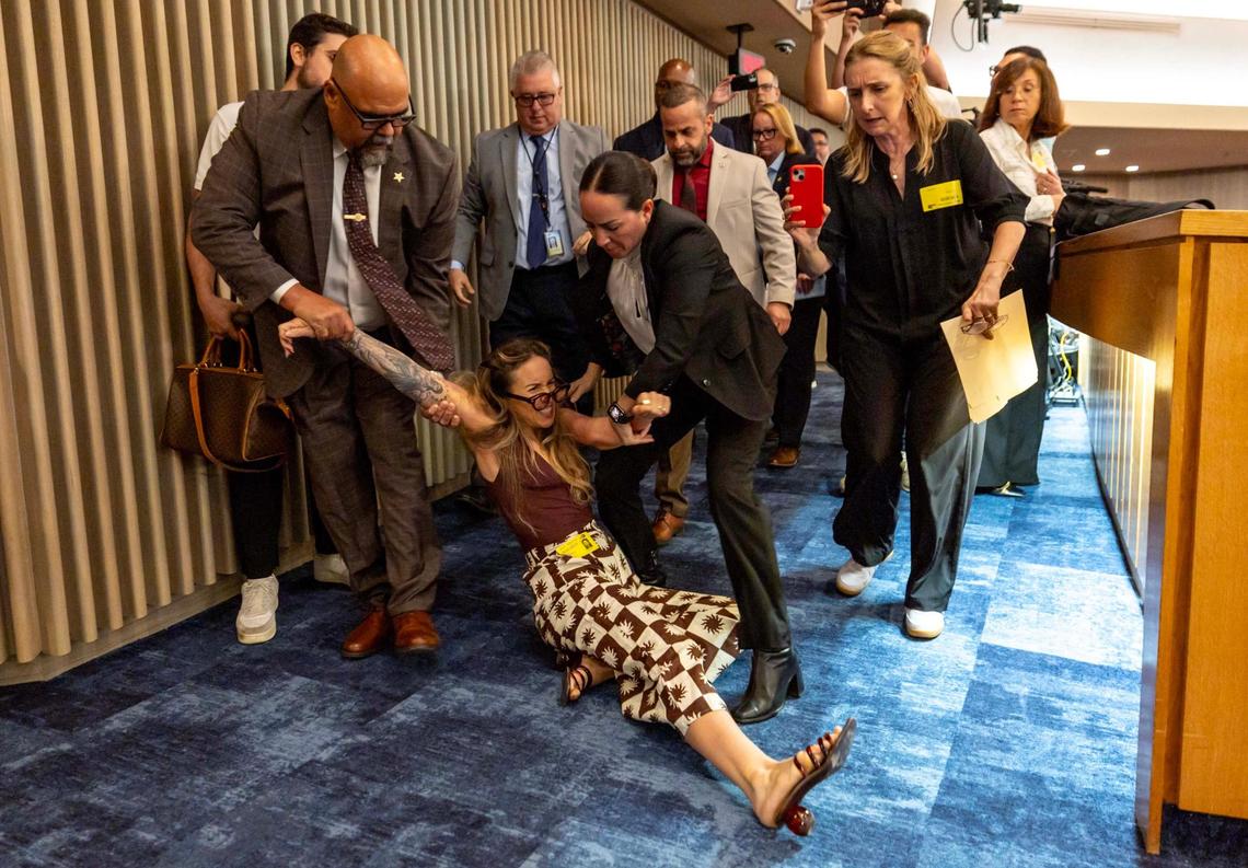 Camila Ramos is forcibly removed from the commission chambers by officers during a Miami-Dade County Commission meeting at the Stephen P. Clark Government Center on Thursday, June 26, 2025, in Miami.