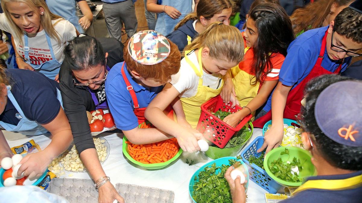 Students rush to get their ingredients for their dishes during the culinary competition Wednesday at Scheck Hillel Community School in North Miami Beach. Rachel Goldzal, the 13-year-old who became the first kosher-observant champion of the Food Network’s cooking reality show, “Chopped,” judged the student competition.