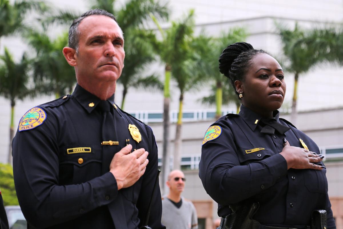City of Miami police officers listen to the national anthem during a Give Miami Day event at the Thomson Plaza for the Arts at the Arsht Center for the Performing Arts, in Miami, Florida, on Thursday, November 21, 2019.