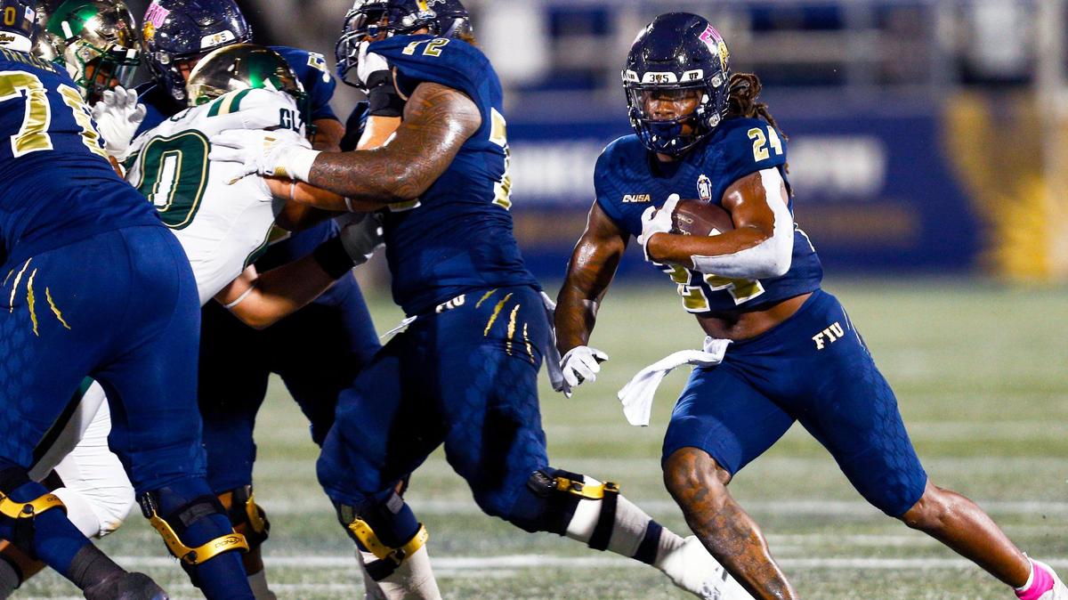 Florida International University running back D’vonte Price (24) runs past University of North Carolina at Charlotte 49ers defensive linemen during the second quarter of an NCAA Conference USA football game at Riccardo Silva Stadium in Miami, Florida, on Friday, October 8, 2021.