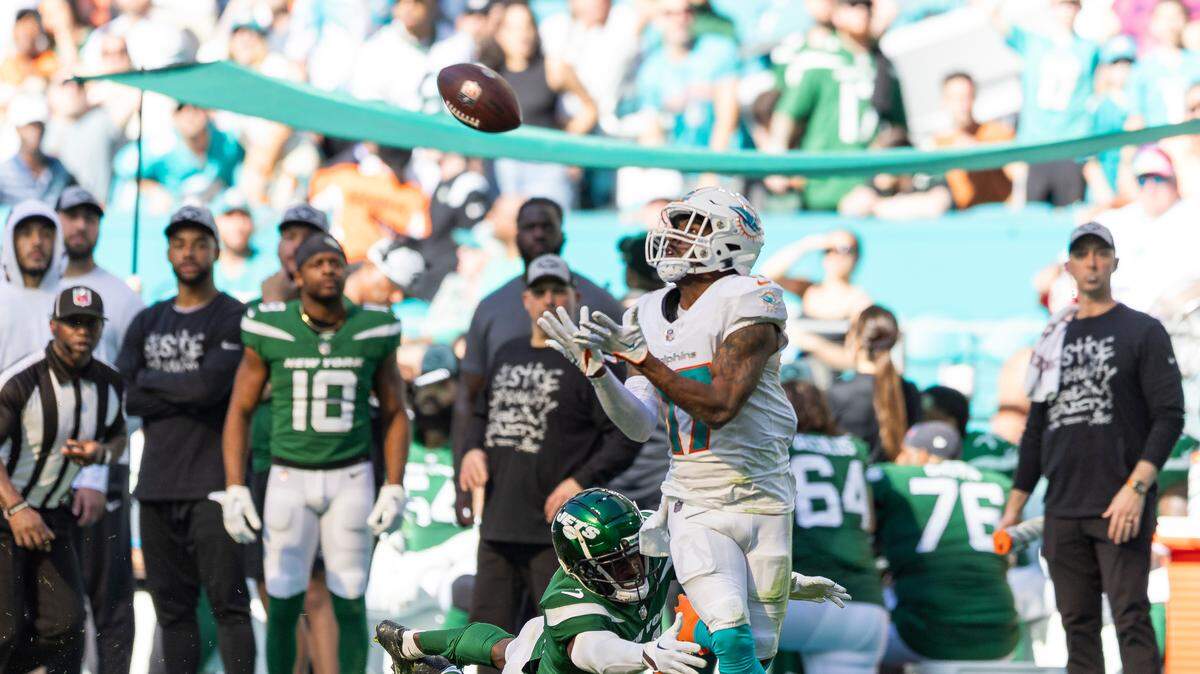 Miami Dolphins wide receiver Jaylen Waddle (17) catches a pass as New York Jets cornerback D.J. Reed (4) fails to tackle him in the second quarter of an NFL game at Hard Rock Stadium on Sunday, Dec. 17, 2023, in Miami Gardens, Fla.