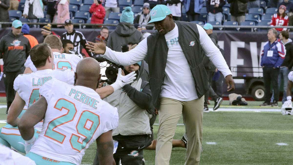 Miami Dolphins head coach Brian Flores greets players as they warm up before an NFL football game against the New England Patriots, Sunday, Dec. 29, 2019, in Foxborough, Mass.