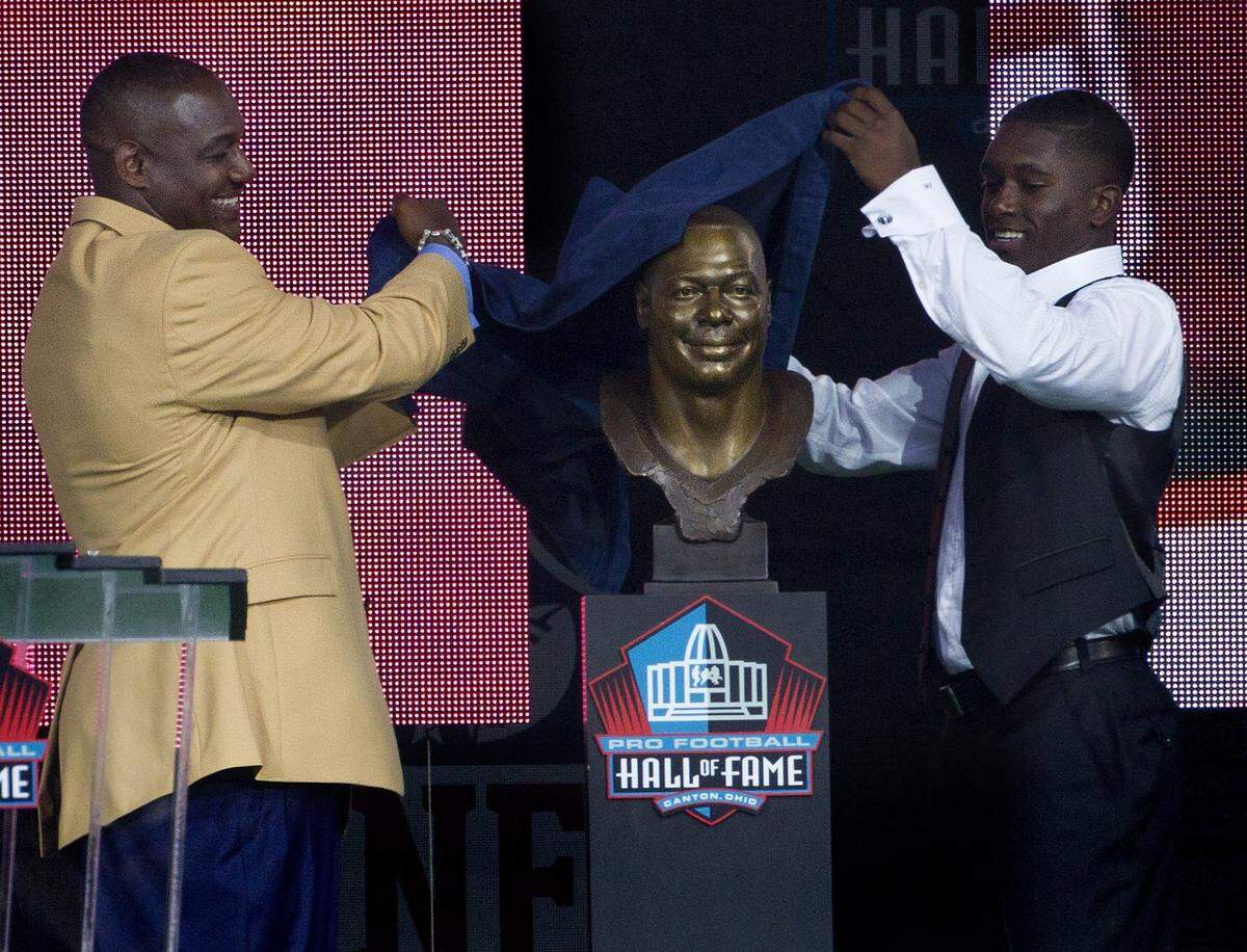 Tampa Bay Buccaneers linebacker Derrick Brooks and his presenter, son Decalon Brooks, 15, unveil the bust during the Hall of Fame Enshrinement Ceremony in Canton, Ohio, on Saturday, Aug. 2, 2014. (Dirk Shadd/Tampa Bay Times/MCT)