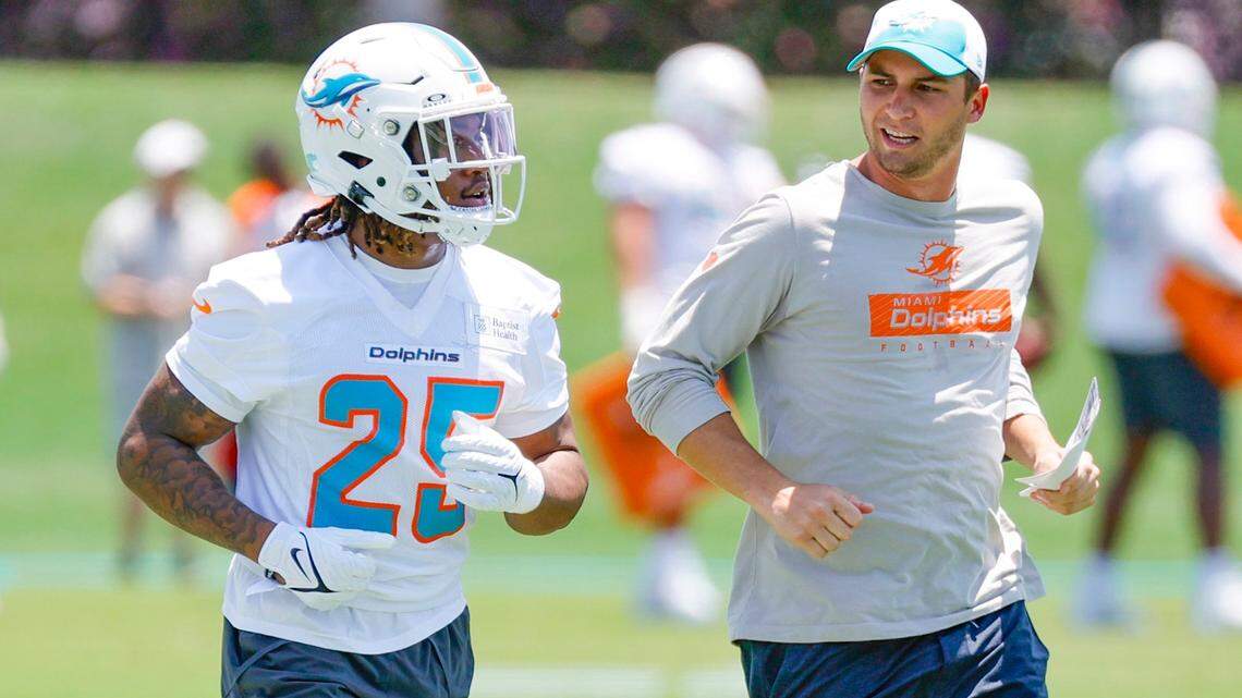 Miami Dolphins Jaylen Wright (25) runs with offensive assistant Max McCaffrey during practice at the Baptist Health Training Complex in Miami Gardens, Florida on Friday, May 10, 2024.