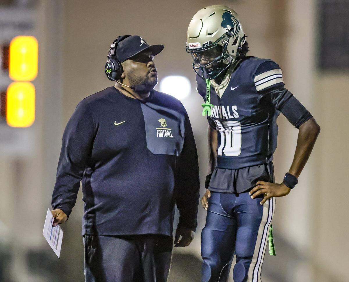 Immaculata-La Salle High School football head coach Helder Valle speaks with quarterback Nate Merrell Jr. (10) during a timeout during the game against Mater Academy at Immaculata-La Salle High School in Miami, FL, on Friday, October 24, 2025.