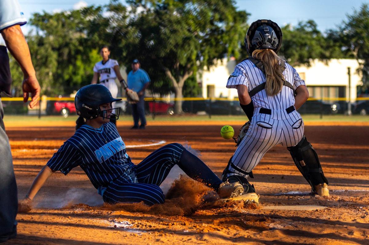 Coral Springs Charter base runner Gio Gurgel (19) slides into home for a run as Western catcher Kennedy Butter (9) waits for the throw during the BCAA BIG 8 Softball Championship against Western in Pompano Beach, Florida, on Thursday, April 25, 2024.