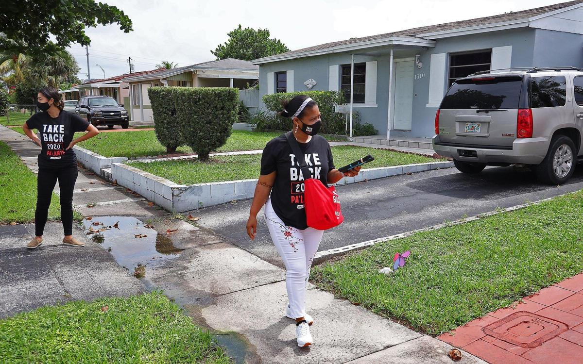 M.J. Leira, of the local labor union 355, left, and canvasser Ketty Toussaint Rene walk through a North Miami neighborhood. Members of Unite Here, a Local 355 union office, knocked on doors as they canvassed for the Biden campaign on Sunday, October 4, 2020.