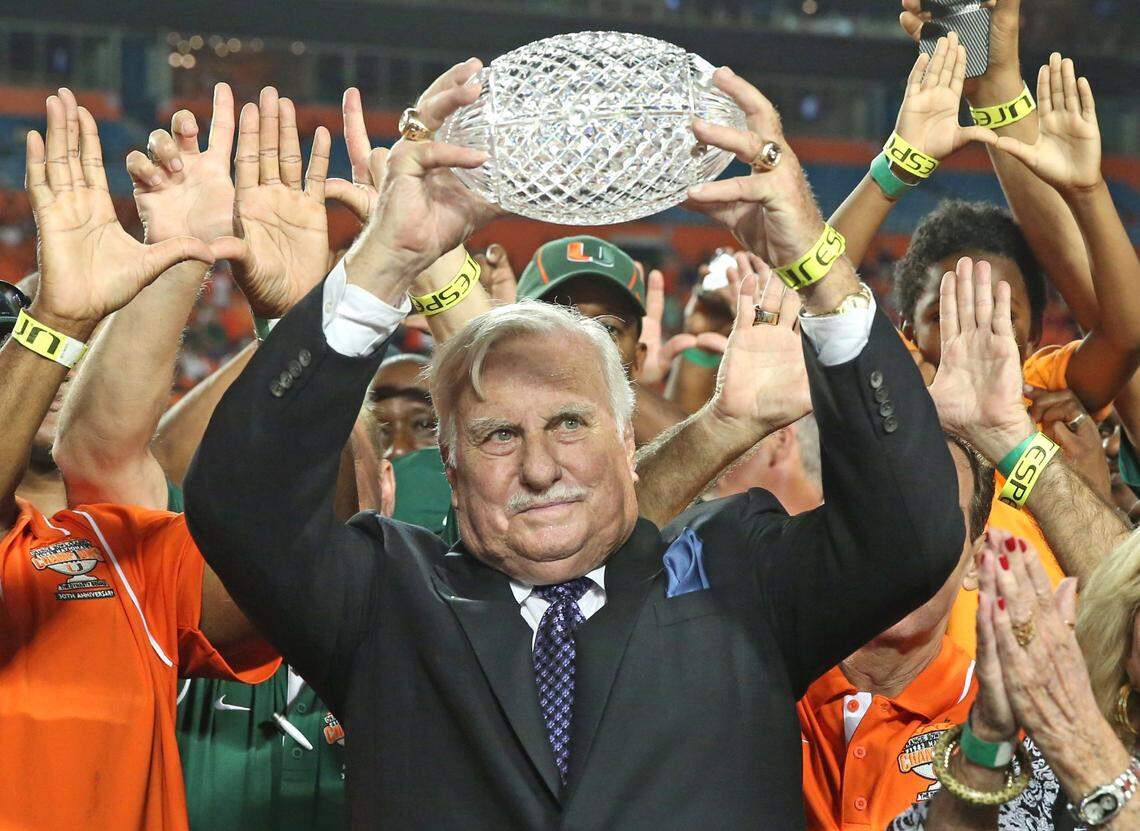 Howard Schnellenberger raises the 1983 NCAA National Championship Trophy during half time ceremony at the University of Miami vs Florida Atlantic University football game on Friday, August 30, 2013.