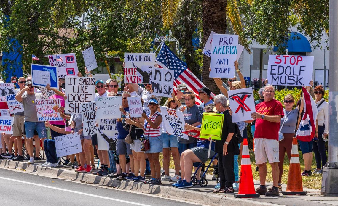 A group of “outraged” people protested in front of the Fort Lauderdale Tesla Showroom against the recent actions of President Donald Trump administration, in which Elon Musk now plays a key role — including mass layoffs, the removal of federal programs and funding for medical research, on Saturday March 15, 2025.