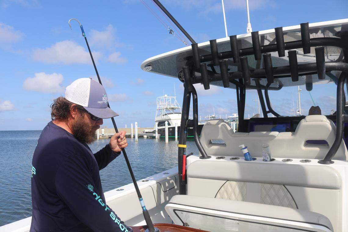 Tyler Massey, a charter boat captain, cleans his Hot Spots charter boat at the Santa Rosa Yacht & Boat Club on Friday, May 16, 2025. One offshore fish farm won’t be a big deal, Massey said, “but it opens the door for other ones to come.”